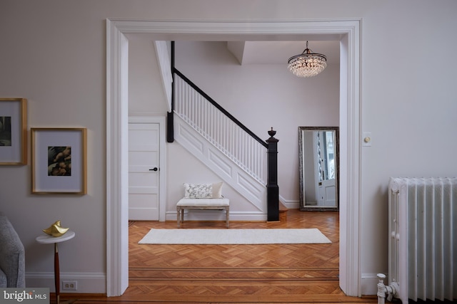 interior space featuring a chandelier, baseboards, and radiator heating unit