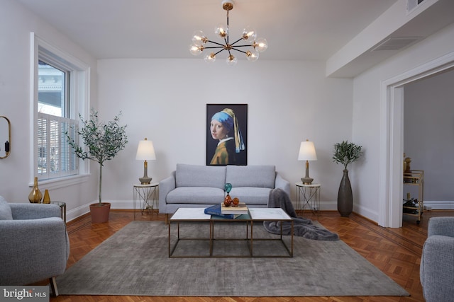 living area with a notable chandelier, visible vents, and baseboards