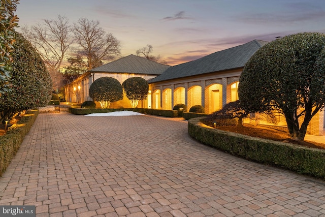 view of front facade featuring decorative driveway and brick siding