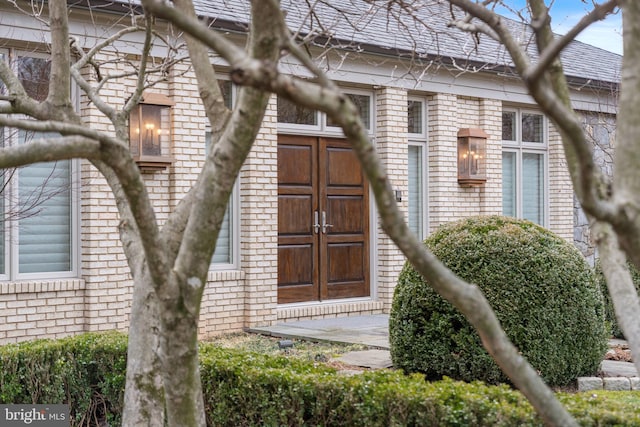 doorway to property featuring brick siding