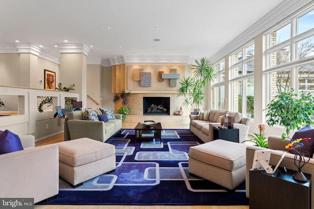 living room featuring crown molding, recessed lighting, plenty of natural light, and a premium fireplace