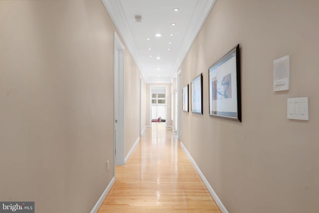 hallway with baseboards, recessed lighting, light wood-type flooring, and crown molding