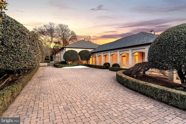 view of front of house with brick siding and decorative driveway