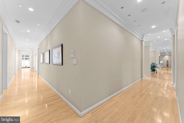 hall featuring light wood-type flooring, baseboards, ornamental molding, and recessed lighting