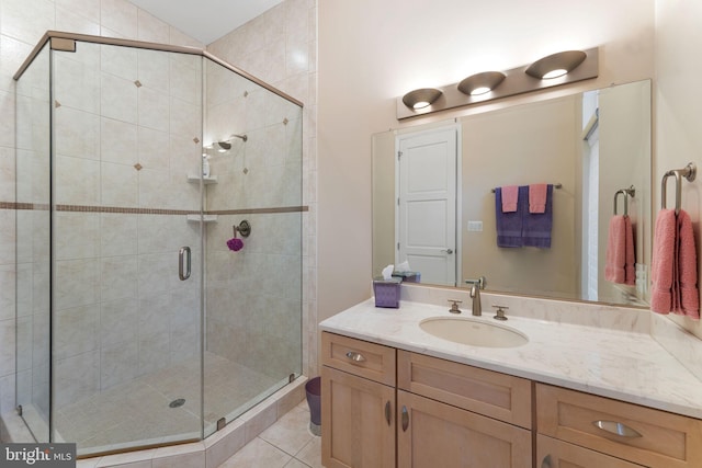 full bathroom with tile patterned flooring, vanity, and a shower stall