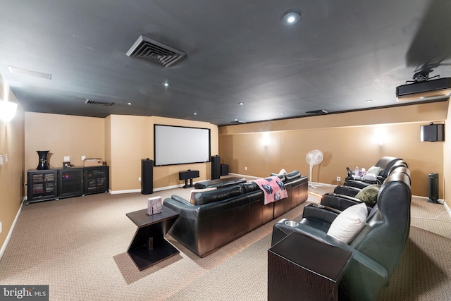 cinema room featuring visible vents, light carpet, and baseboards