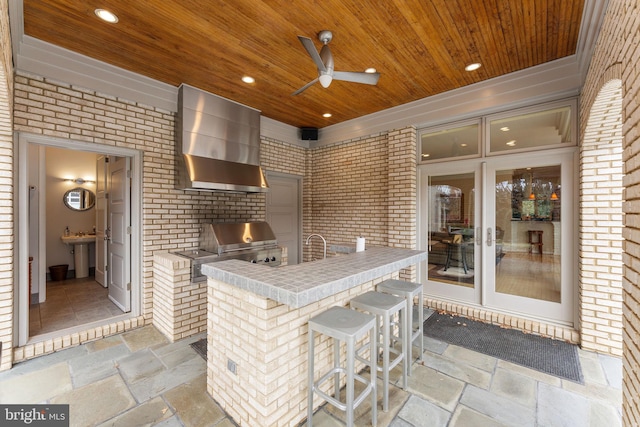 view of patio / terrace with area for grilling, an outdoor kitchen, a ceiling fan, a sink, and outdoor wet bar