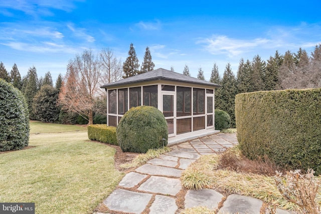 view of property exterior featuring a sunroom and a lawn