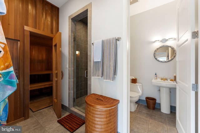 full bath featuring toilet, a sink, a sauna, a shower stall, and tile patterned floors