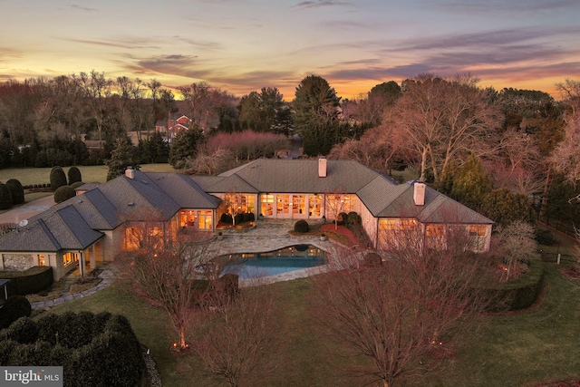 exterior space with an outdoor pool and a lawn