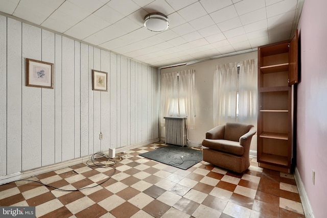 living area with radiator, baseboards, and light floors