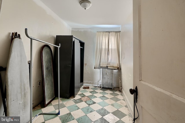 interior space featuring radiator heating unit, baseboards, and tile patterned floors