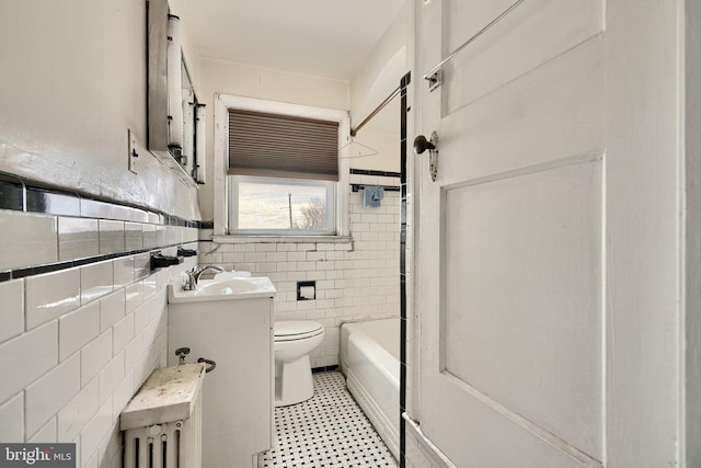 full bath with toilet, vanity, and tile walls