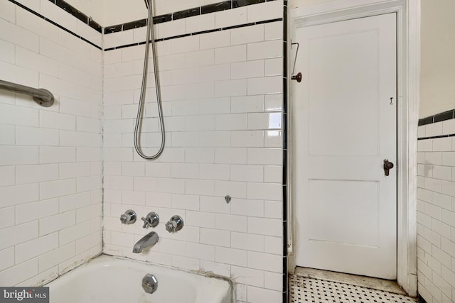 bathroom with tub / shower combination and tile walls