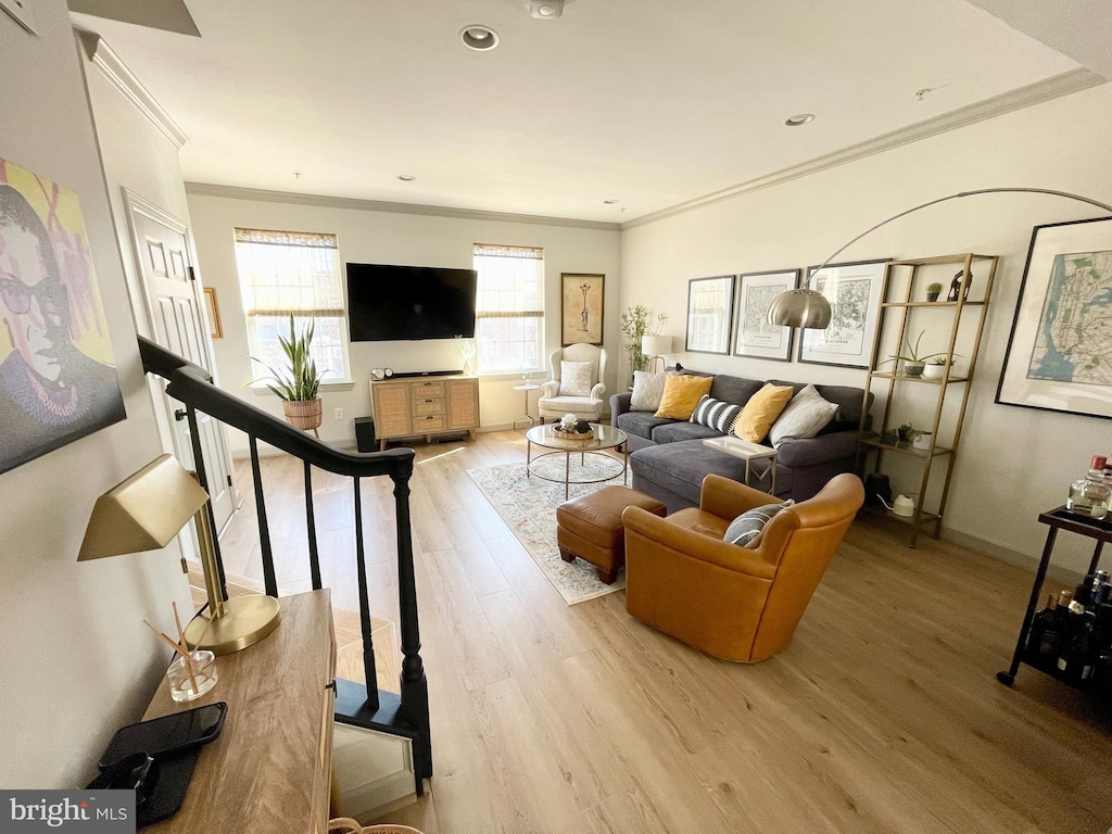 living area featuring recessed lighting, wood finished floors, baseboards, stairs, and crown molding