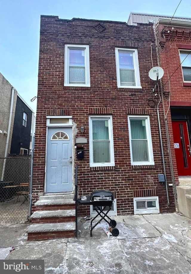 townhome / multi-family property with entry steps and brick siding