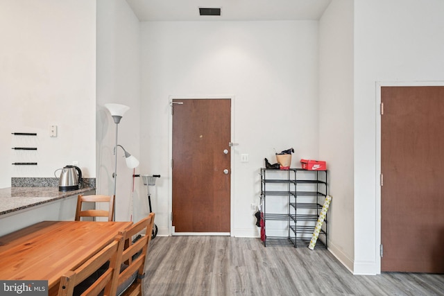 office space with light wood finished floors, visible vents, and baseboards