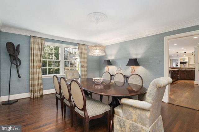 dining area featuring wallpapered walls, dark wood finished floors, baseboards, and ornamental molding