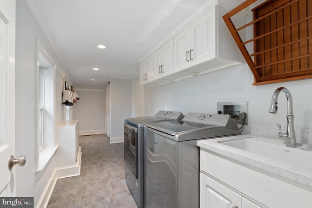 laundry room with washer and clothes dryer, a sink, recessed lighting, cabinet space, and baseboards