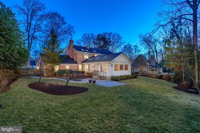 view of front of home with a front yard, fence, and a chimney