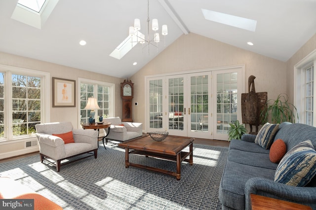 living area featuring lofted ceiling with skylight, a chandelier, recessed lighting, french doors, and wood finished floors