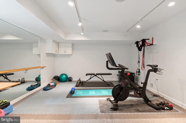 workout area featuring rail lighting and baseboards