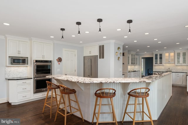 kitchen featuring dark wood-style flooring, stainless steel appliances, glass insert cabinets, white cabinetry, and crown molding