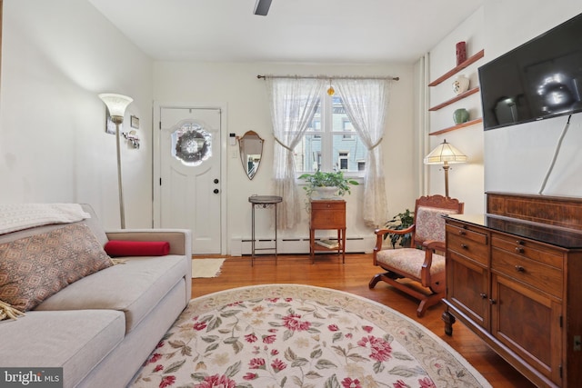 sitting room with baseboard heating and wood finished floors