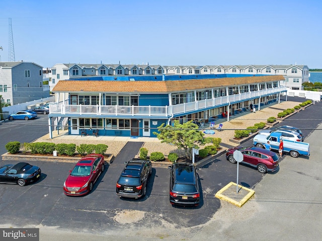 view of building exterior with uncovered parking and a residential view