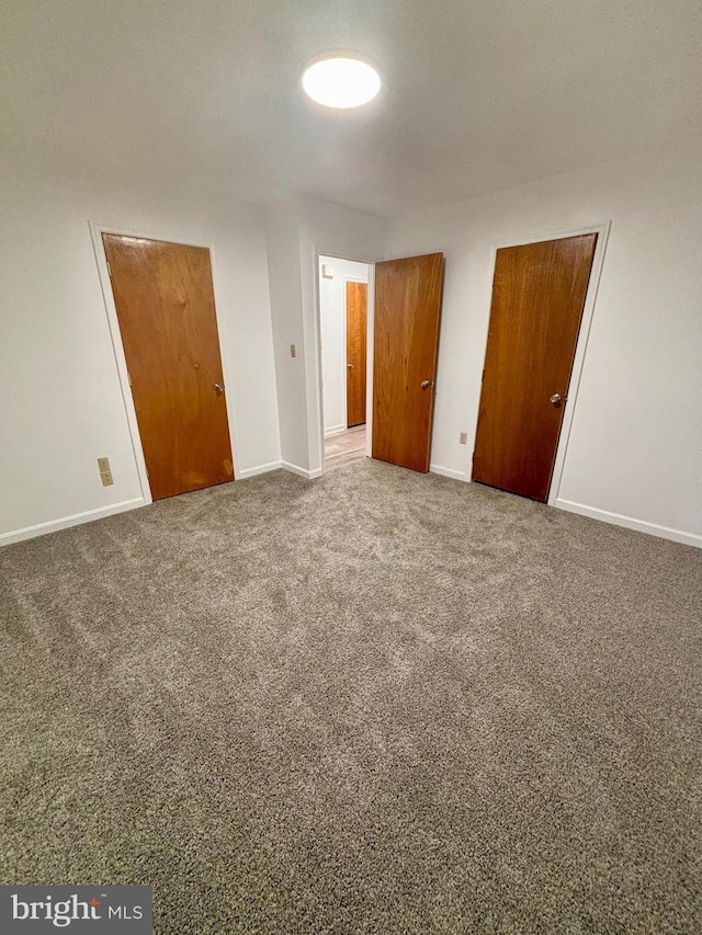 unfurnished bedroom with carpet flooring and baseboards