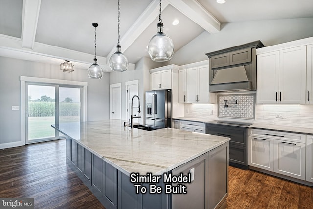 kitchen featuring pendant lighting, a large island, high end fridge, a sink, and ventilation hood