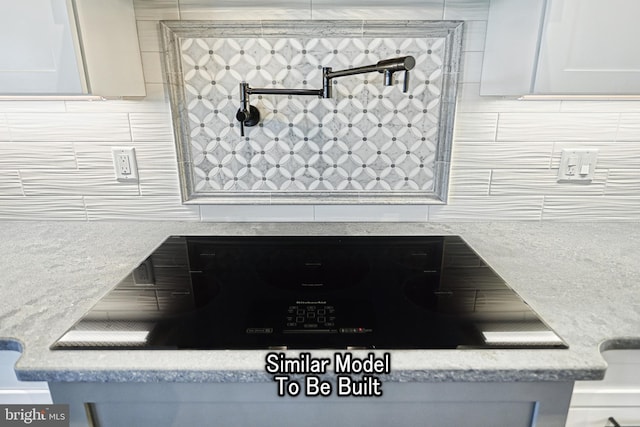 room details with light stone countertops and white cabinetry