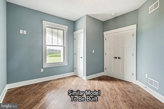 entrance foyer featuring visible vents, baseboards, and wood finished floors