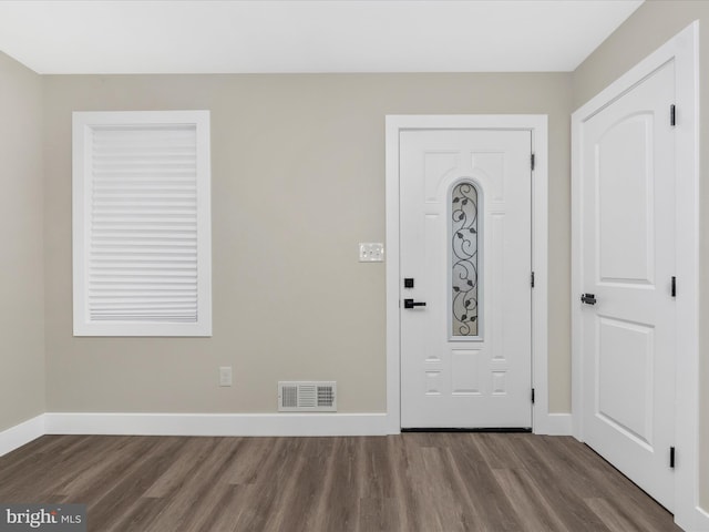 foyer featuring wood finished floors, visible vents, and baseboards