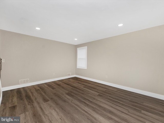 unfurnished room featuring recessed lighting, visible vents, dark wood finished floors, and baseboards