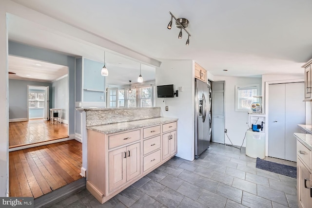 kitchen featuring baseboards, hanging light fixtures, stainless steel refrigerator with ice dispenser, light stone countertops, and dark wood-style floors