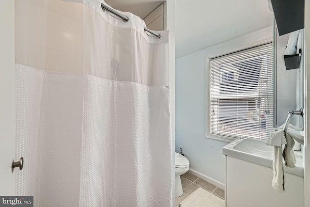 bathroom with a sink, toilet, and tile patterned floors