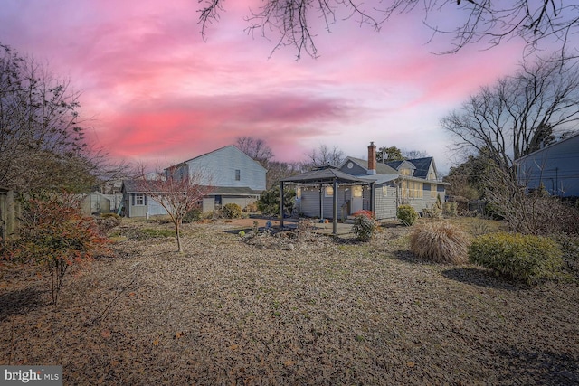 rear view of house with a gazebo and a chimney