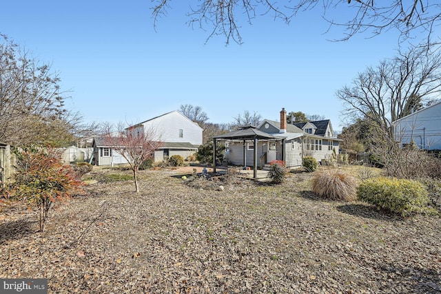 back of house featuring a gazebo and a chimney