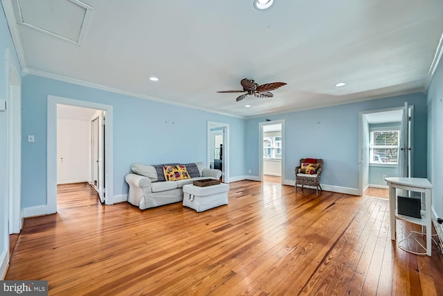 living area with recessed lighting, crown molding, light wood-style flooring, and baseboards