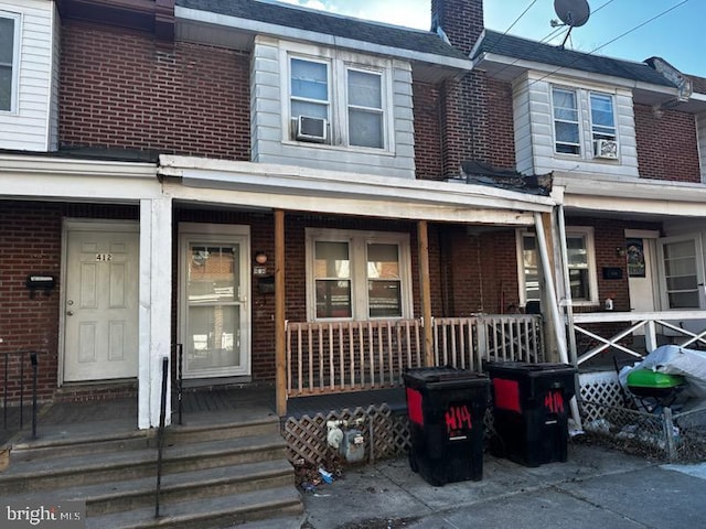 view of front of house with a porch and brick siding