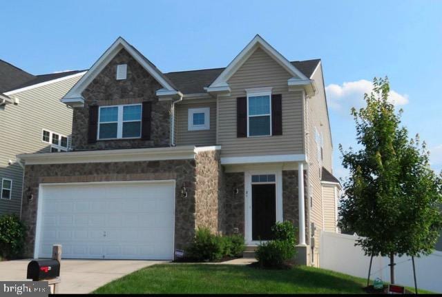 view of front of house with a garage, a front yard, stone siding, and concrete driveway