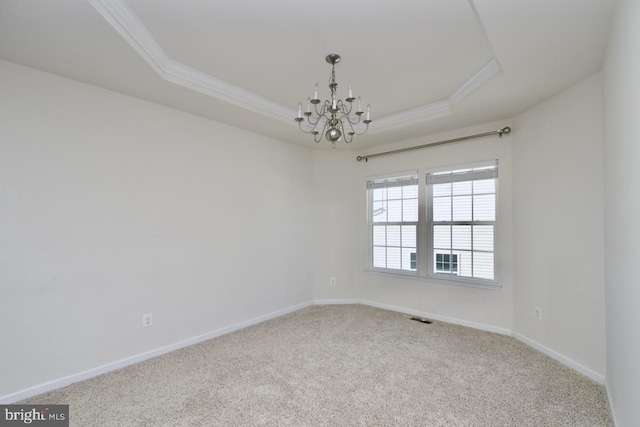 unfurnished room with a tray ceiling, carpet, crown molding, a notable chandelier, and baseboards