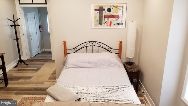 bedroom featuring wood finished floors and baseboards