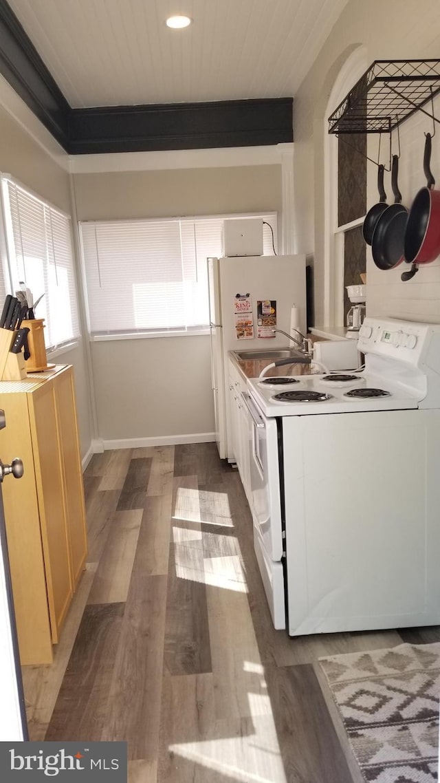 kitchen with light wood-type flooring, fridge, white electric stove, and baseboards