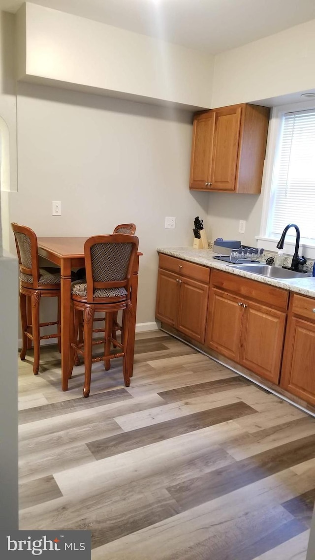 kitchen featuring light wood-style floors, light countertops, and a sink