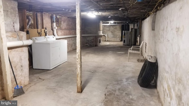 unfinished basement with water heater and washing machine and clothes dryer