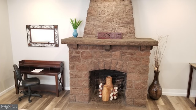 room details featuring a fireplace, wood finished floors, and baseboards