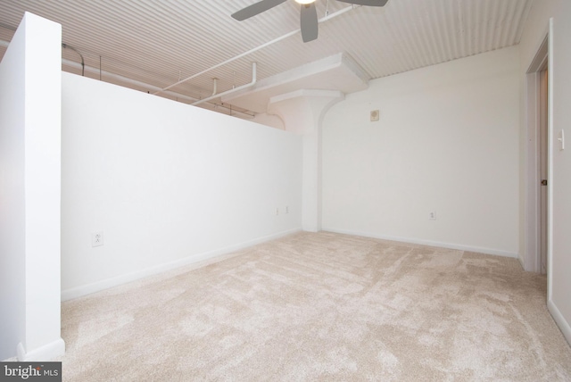 unfurnished room with carpet, a ceiling fan, and baseboards