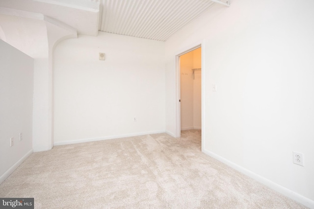 spare room featuring carpet flooring and baseboards